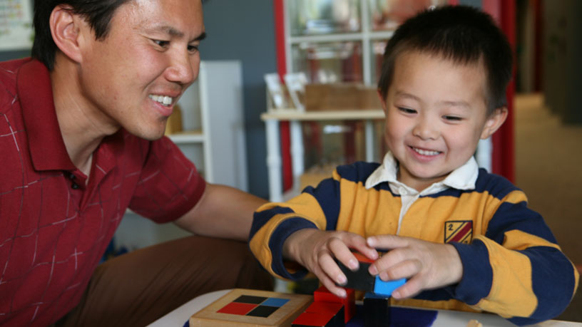 Child playing with snow in a bowl